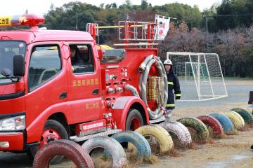 タイヤの横を徐行で走行する消防車両の写真