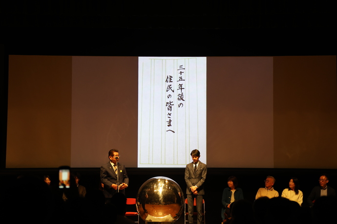 当時の町長からの手紙を代読する籾山町長