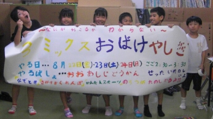 オバケ屋敷の垂れ幕をもつ子どもたち